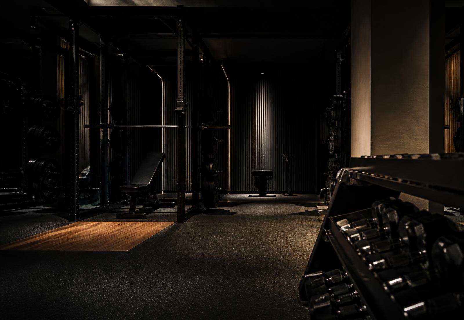 Dimly lit strength floor with racks and platforms